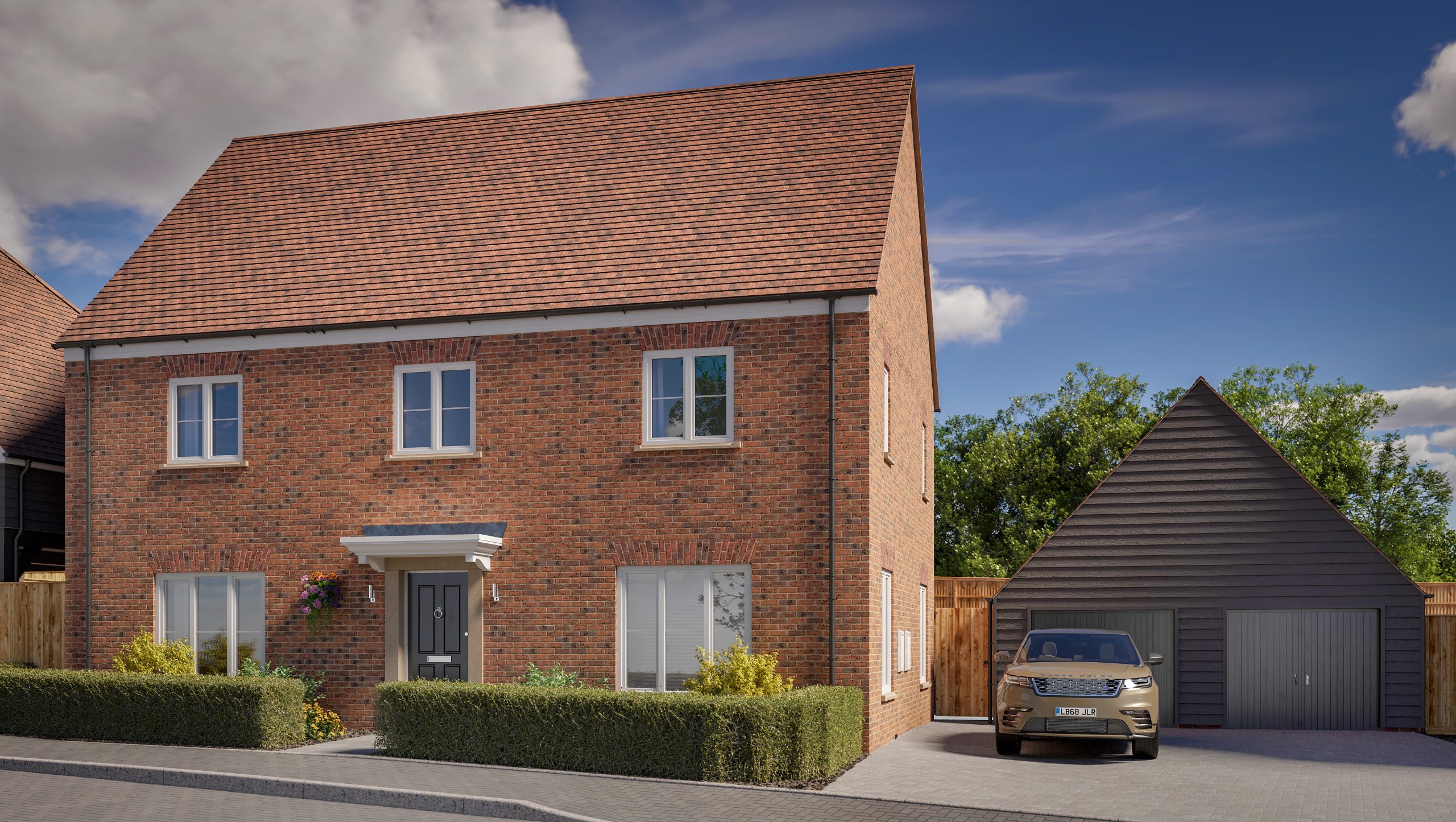 Two-story brick house with a well kept front garden and a large double garage with a car parked in front.