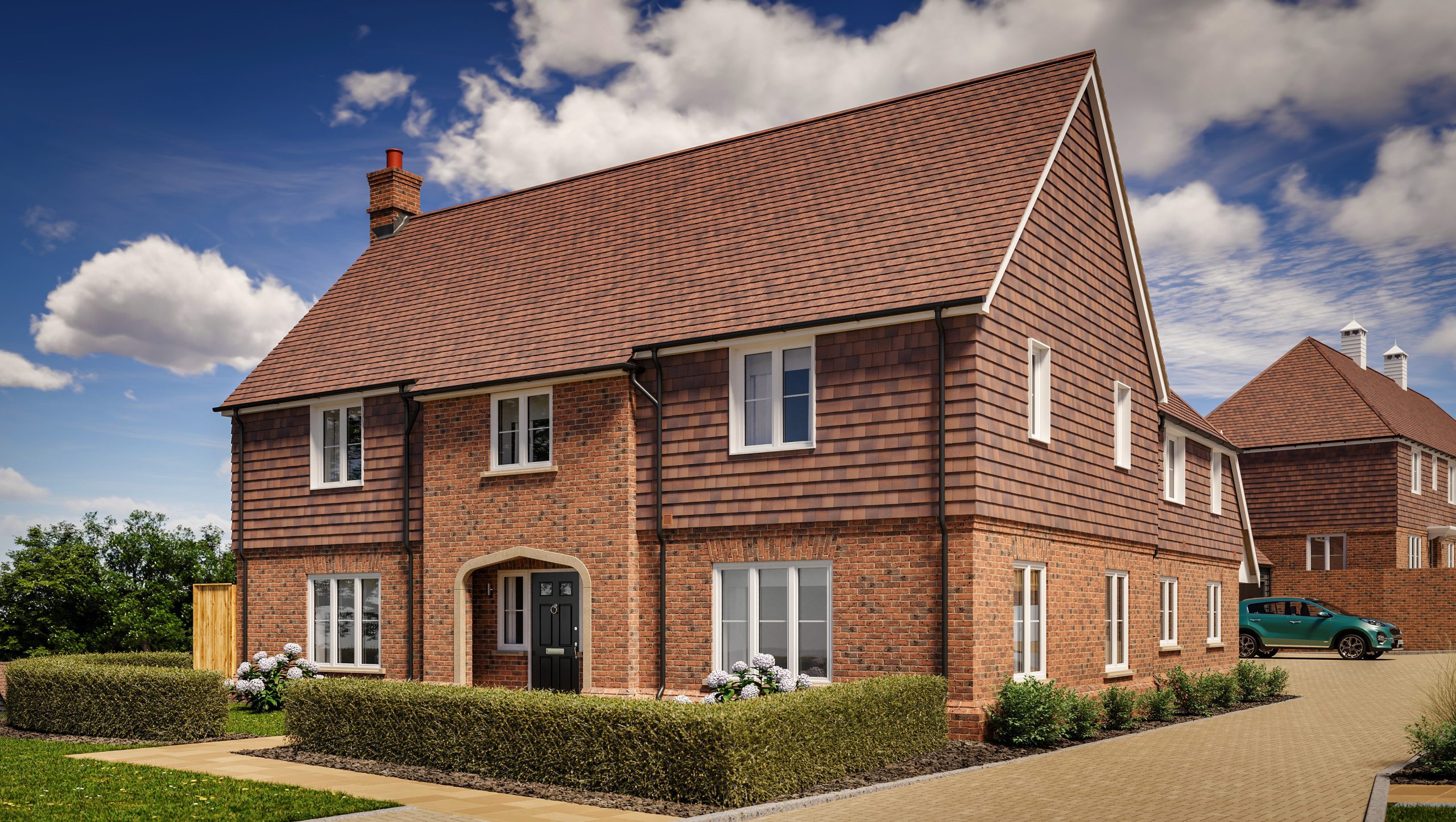 A large two-story brick house with a hedge in the front garden and a garage towards the back.
