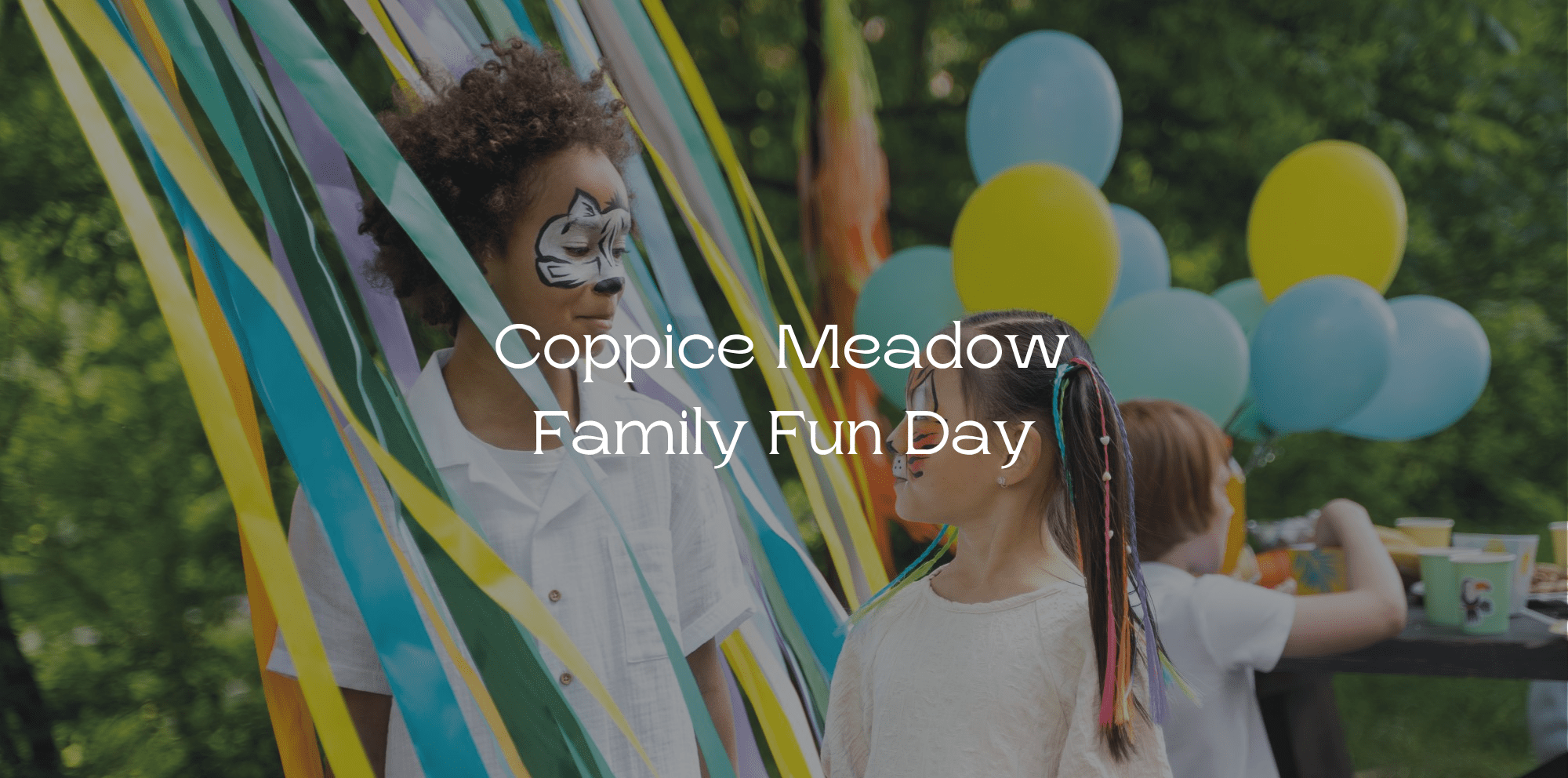 Two children with face paint playing together at a garden party